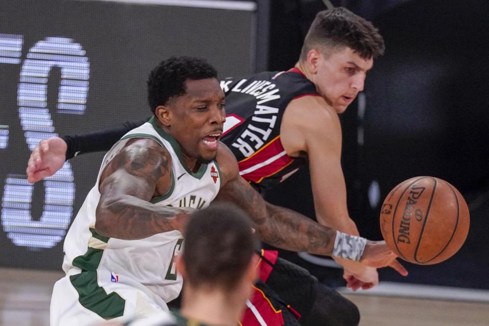 Milwaukee Bucks' Eric Bledsoe battles for a loose ball with Miami Heat's Tyler Herro during the first half of an NBA conference semifinal playoff basketball game Sunday, Sept. 6, 2020, in Lake Buena Vista, Fla. (AP Photo/Mark J. Terrill)