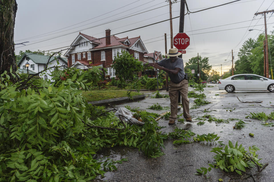 Charlie Milton clears tree branches from Quarrier Street after a suspected tornado tore through Charleston, W.Va., Monday, June 24, 2019. (Craig Hudson/Charleston Gazette-Mail via AP)
