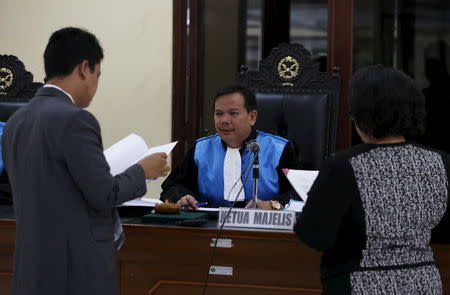 An Indonesian judge Ujang Abdullah (C) talks to Leonard Arpan (L), the lawyer for two convicted Australian drug traffickers on death row, during their appeal hearing inside Jakarta courtroom, March 19, 2015. REUTERS/Beawiharta