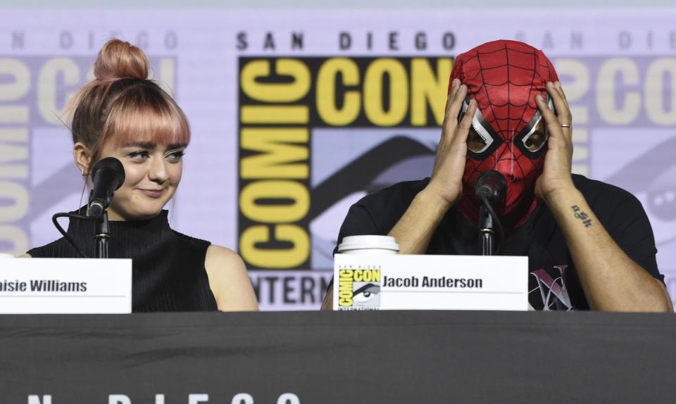 Maisie Williams, left, looks at Jacob Anderson as he puts on a Spider-Man mask during the "Game of Thrones" panel on day two of Comic-Con International on Friday, July 19, 2019, in San Diego. (Photo by Chris Pizzello/Invision/AP)