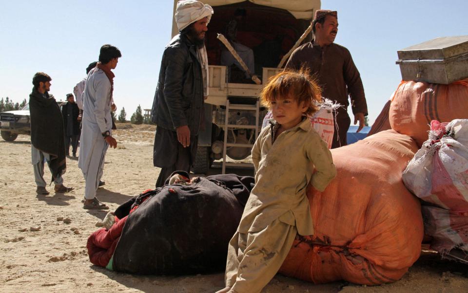 A young boy by his family's belongings in a makeshift camp in Ghazni