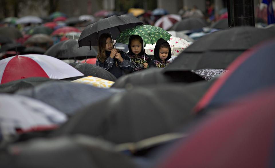 First Nations' children wait in the rain to take part in a Truth and Reconciliation march in Vancouver