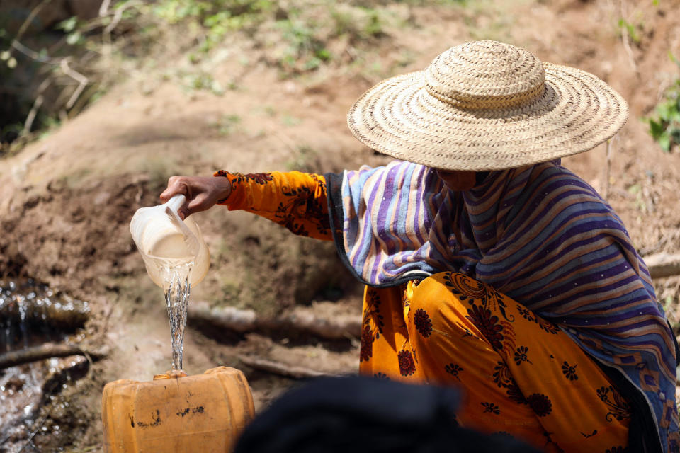 Khadija Mohammad fills jerrycans from a stream after a 2Km-walk from home, a commute she makes daily, to fetch water and wash her children's clothes in the village of Bani Shaybah on the outskirts of Yemen's third city of Taez, on March 8, 2022. (Photo by AHMAD AL-BASHA / AFP) (Photo by AHMAD AL-BASHA/AFP via Getty Images)