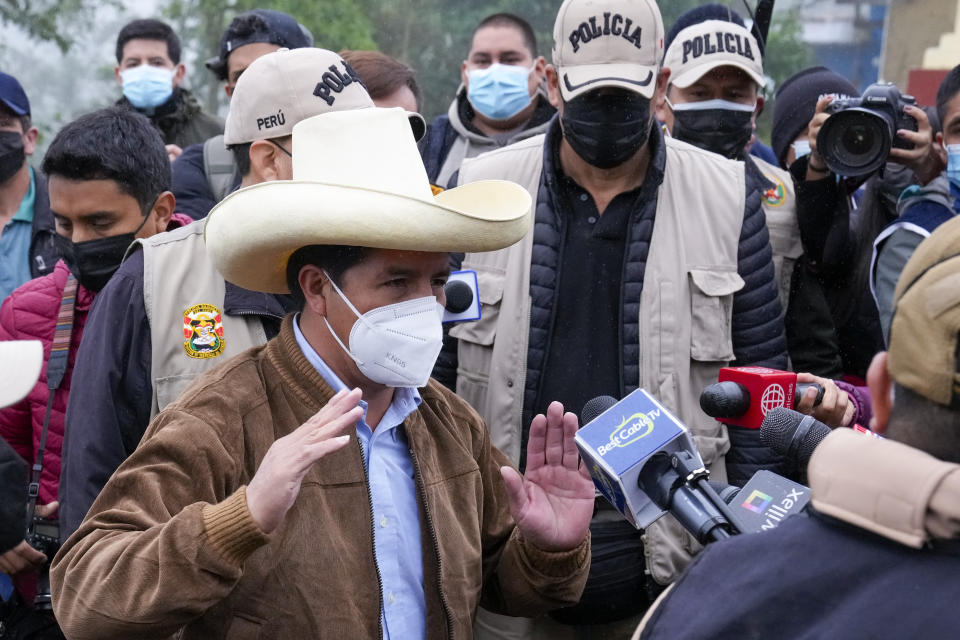 Presidential candidate Pedro Castillo talks to reporters at his hometown in Chugur, Peru, Sunday, June 6, 2021. Peruvians will head to the polls Sunday in a presidential run-off election to choose between Castillo, a political novice who until recently was a rural schoolteacher, and Keiko Fujimori, the daughter of jailed ex-President Alberto Fujimori. (AP Photo/Martin Mejia)