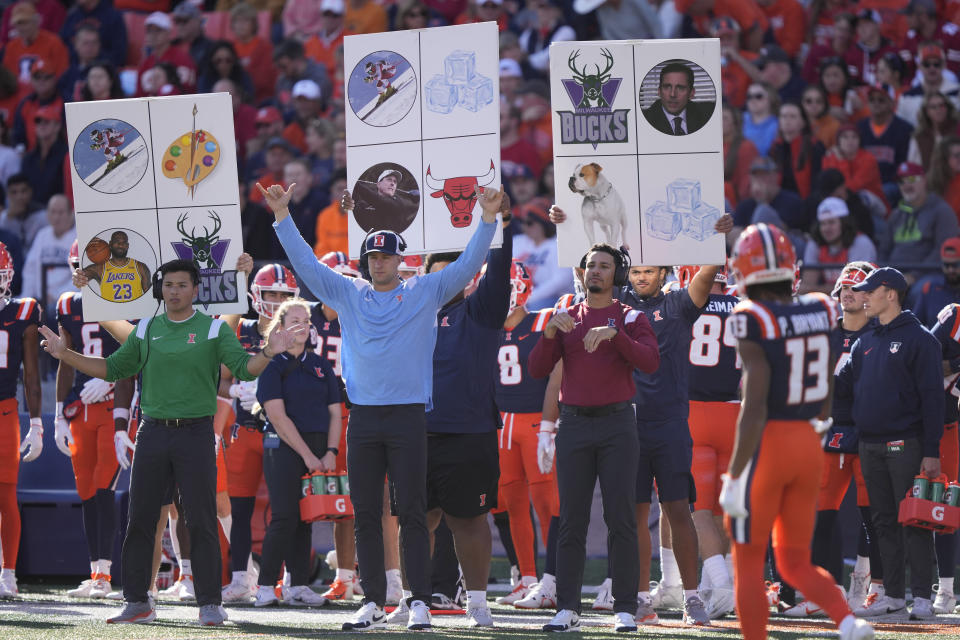 Members of the Illinois football team send in signals during an NCAA college football game against Wisconsin Saturday, Oct. 21, 2023, in Champaign, Ill. (AP Photo/Charles Rex Arbogast)