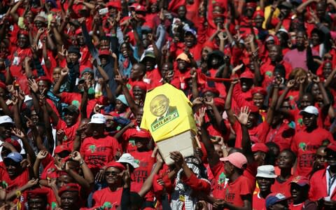 EFF supporters hold a mock coffin bearing the face of the ruling African National Congress (ANC) President Cyril Ramaphosa - Credit: AFP