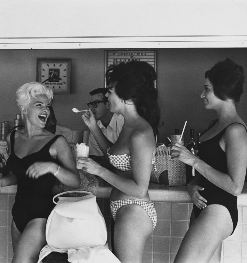 Three women enjoy a beachside ice cream parlor: 1960