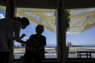 An elderly woman gets a COVID-19 vaccine shot inside the Museum of Tomorrow in Rio de Janeiro, Brazil, Thursday, April 1, 2021. With Brazil’s virus cases and deaths surging, most concert halls and theaters remain closed and some, like the Carnival parade grounds and this science museum, have become vaccination stations. (AP Photo/Bruna Prado)