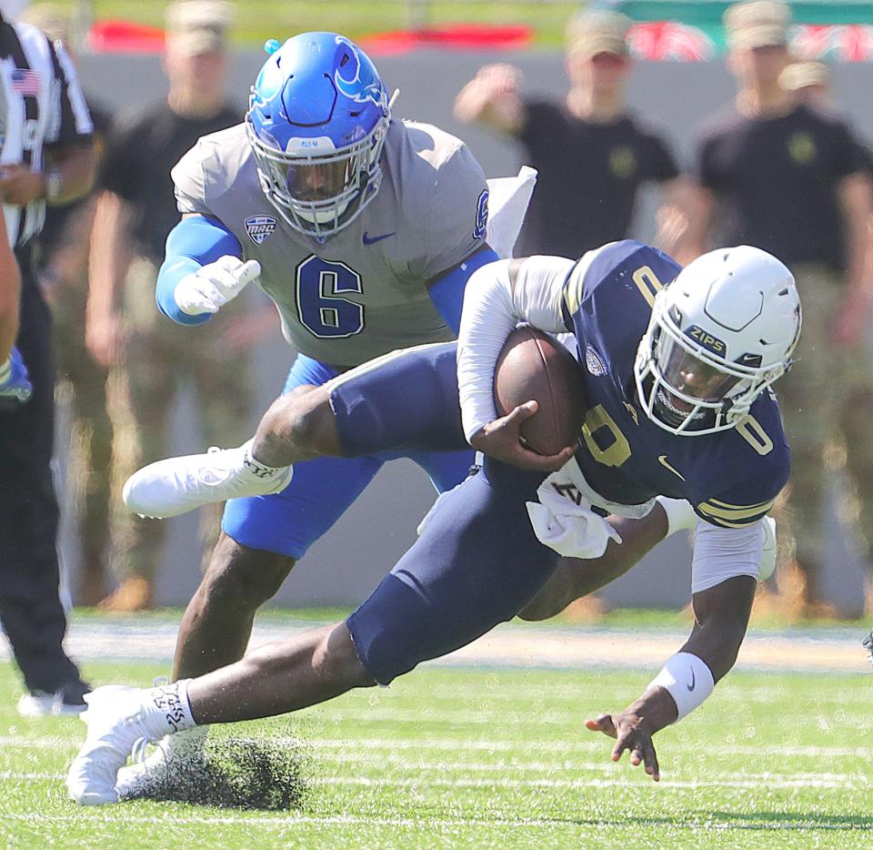 University of Akron quarterback DJ Irons is tripped up by Buffalo defensive end Max Michel on Sept. 30 in Akron.