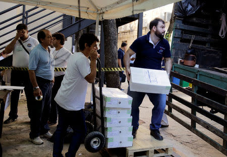 Electoral workers transport materials for the upcoming presidential election of April 22 at the Superior Court of Electoral Justice in Asuncion, Paraguay, April 21, 2018. REUTERS/Jorge Adorno