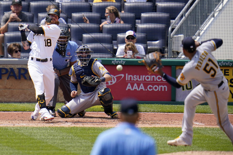 Pittsburgh Pirates' Ben Gamel (18) singles up the middle past Milwaukee Brewers relief pitcher Freddy Peralta (51) during the sixth inning of a baseball game in Pittsburgh, Sunday, July 4, 2021. (AP Photo/Gene J. Puskar)