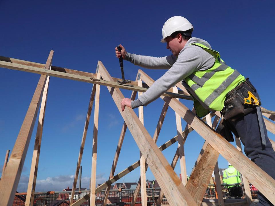 A builder working for Taylor Wimpey builds a roof on an estate in Aylesbury, Britain, February 7, 2017.