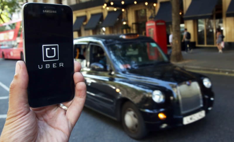 A photo illustration shows the Uber app logo displayed on a mobile telephone, as it is held up for a posed photograph in central London, Britain August 17, 2016. REUTERS/Neil Hall/Illustration