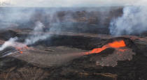 Activity at fissure 6 is seen as lava fountains build a small spatter cone (black mound) from which lava spills out on the surface and flows into a small pond (left of the cone) in Hawaii, U.S. May 25, 2018. Picture taken May 25, 2018. USGS/Handout via REUTERS