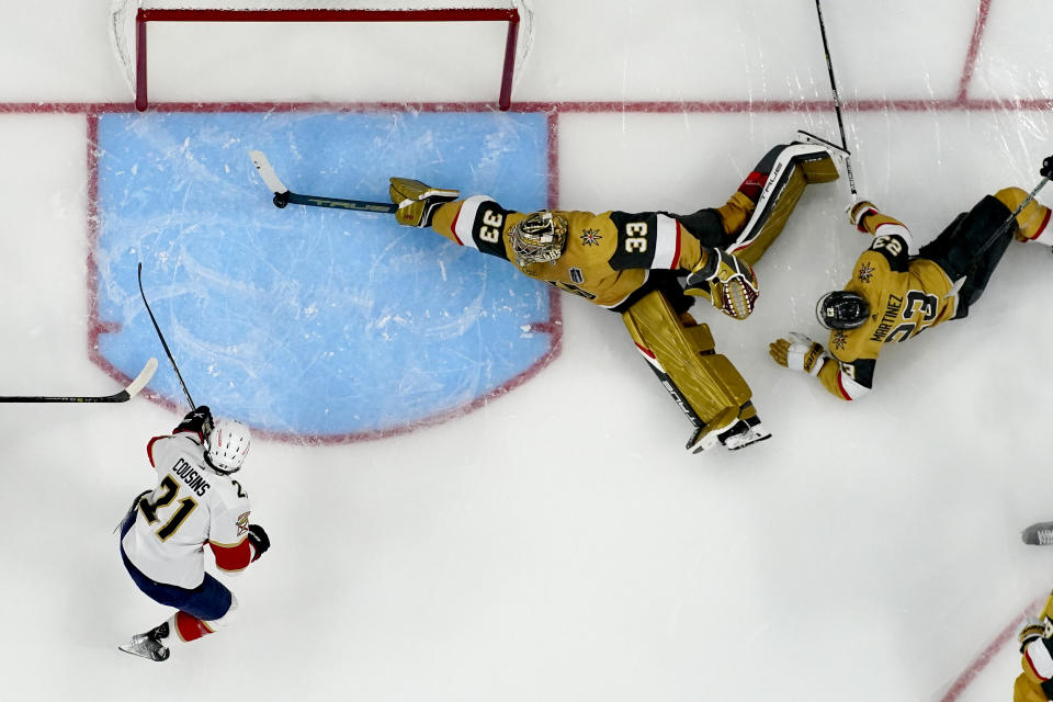 Vegas Golden Knights goaltender Adin Hill (33) blocks a shot on goal by Florida Panthers center Nick Cousins (21) during the second period of Game 1 of the NHL hockey Stanley Cup Finals, Saturday, June 3, 2023, in Las Vegas. (AP Photo/John Locher)