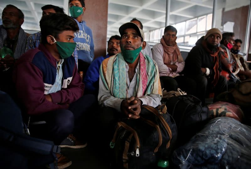 Indian migrant workers wait inside a railway station to board trains to their home states, on outskirts of Srinagar