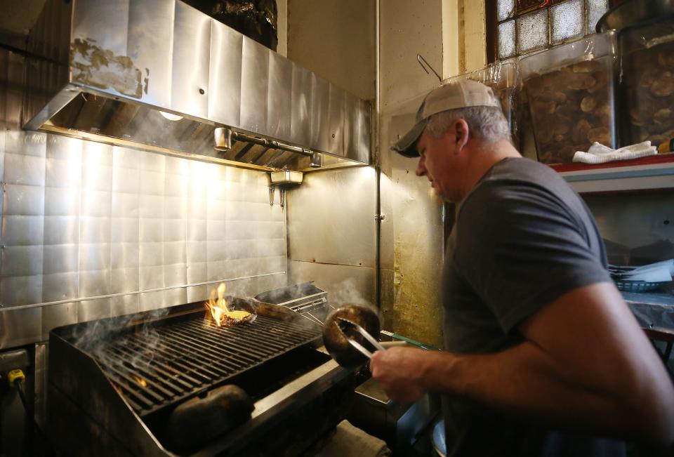 Ringside Café owner Adrian Rosu cooks one of boxing-theme burgers Jan. 6.