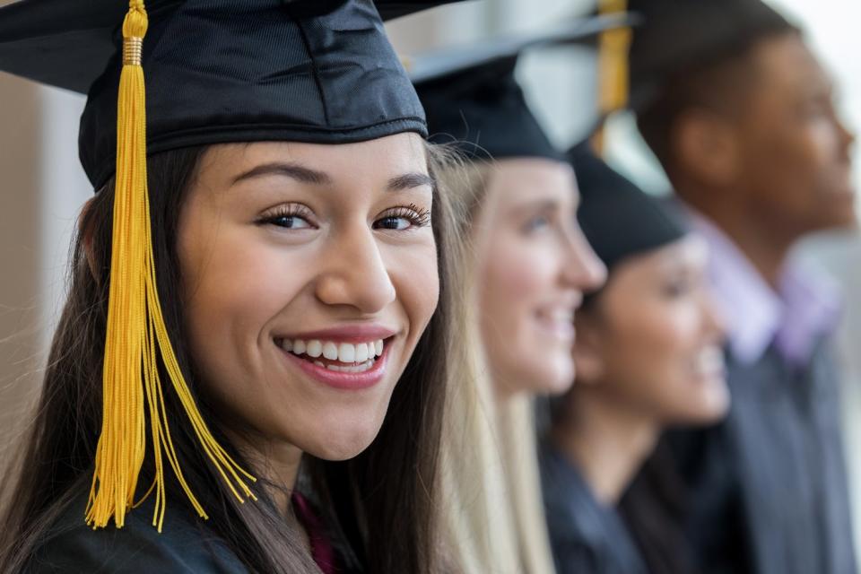 Recent graduates in cap and gown.