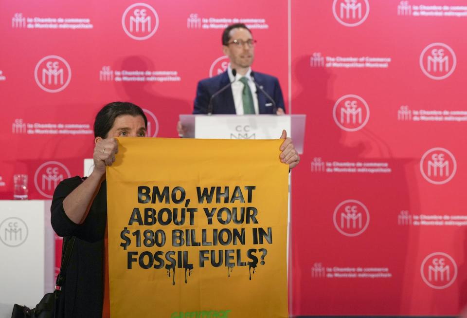 Protesters from Greenpeace interrupt as a Québec BMO executive addresses the Montréal Chamber of Commerce in Montréal in May 2023. THE CANADIAN PRESS/Christinne Muschi