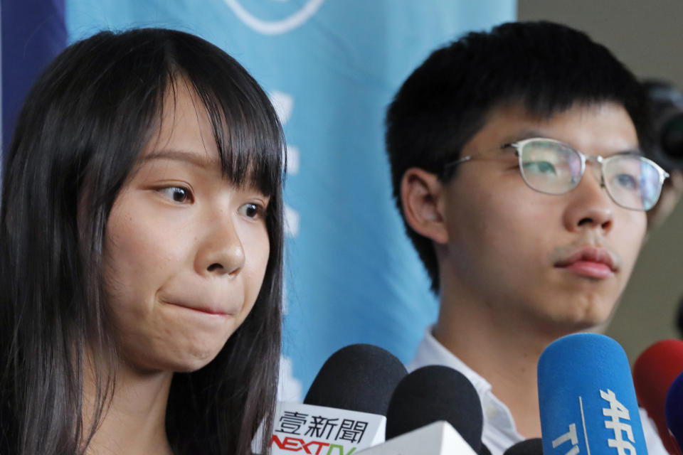 Pro-democracy activists Joshua Wong, right, and Agnes Chow speak to media outside a district court in Hong Kong, Friday, Aug. 30, 2019. Wong and Chow were granted bail Friday after being charged with inciting people to join a protest in June, while authorities denied permission for a major march in what appears to be a harder line on this summer's protests. (AP Photo/Kin Cheung)