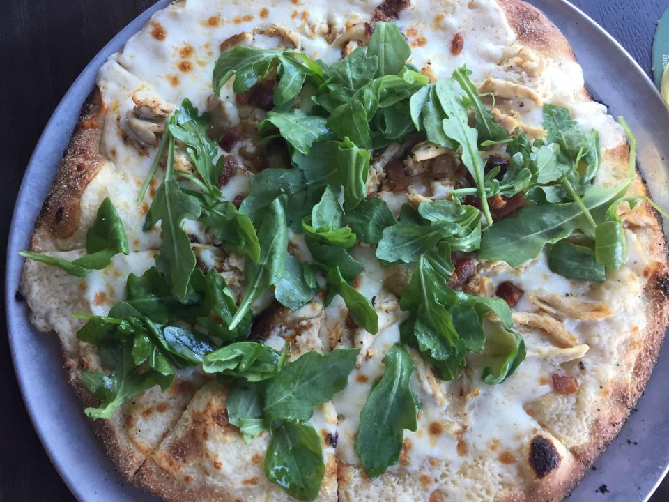 Dogfish Head Brewings & Eats in Rehoboth Beach has several different kinds of wood-fired pizza. This one features IPA cheddar sauce, roasted chicken and arugula.