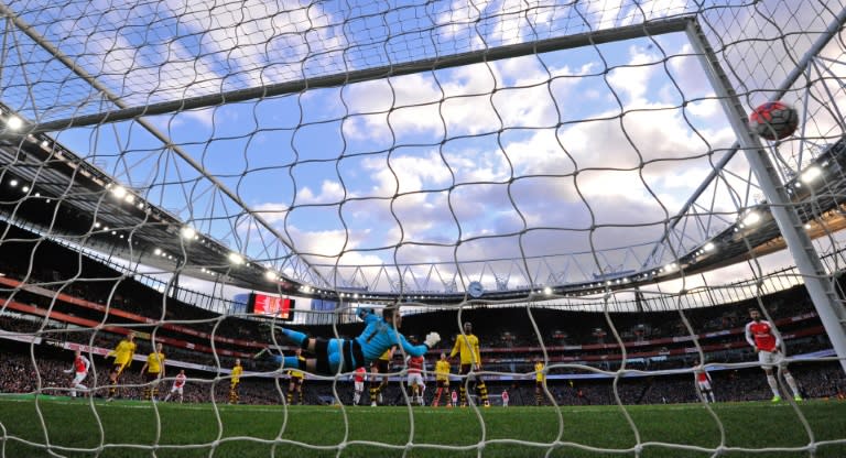 Arsenal's Calum Chambers (L) watches his shot as he scores his team's second goal during the English FA Cup fourth round match against Burnley at the Emirates stadium in London, on January 30, 2016