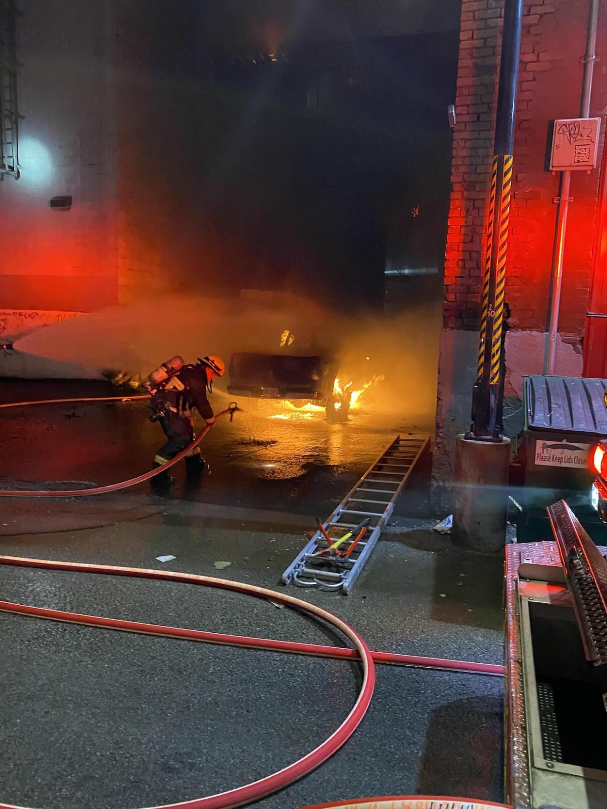 A fire that started in a pickup truck near Granville and Nelson Streets on Saturday morning spread to a nearby hostel and led to significant damage there. (Jon Hernandez/CBC - image credit)