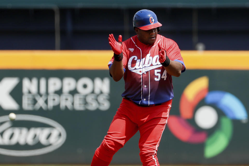 El cubano Alfredo Despaigne aplaude tras llegar a segunda base en un partido del Grupo A del Clásico Mundial de Béisbol, en Taichung, Taiwán, el 10 de marzo de 2023. (AP Foto/I-Hwa Cheng)