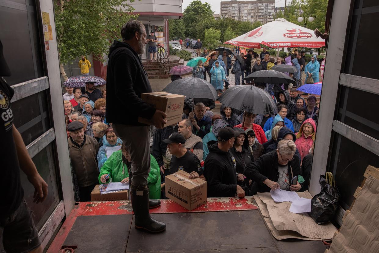 Residents in Kherson gather to collect food and humanitarian aid on Sunday after flooding from explosion of the Kakhovka dam and hydroelectric power plant left the region submerged, and thousands without any power and water. (Getty Images)