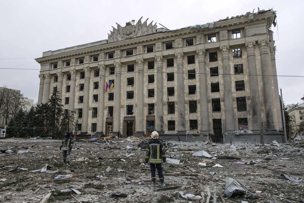 A member of the Ukrainian Emergency Service looks at the City Hall building in the central square following shelling in Kharkiv, Ukraine, Tuesday, March 1, 2022. Russian strikes pounded the central square in Ukraine’s second-largest city and other civilian sites Tuesday in what the country’s president condemned as blatant campaign of terror by Moscow.