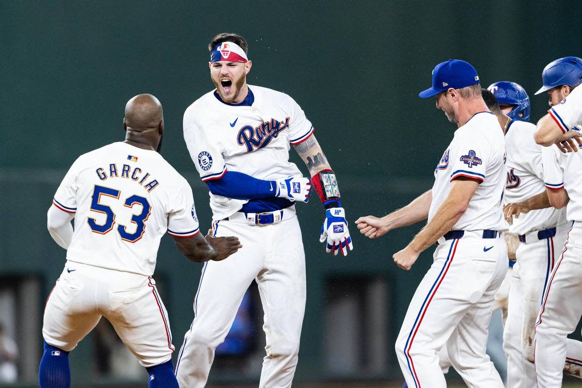 Texas Rangers catcher Jonah Heim (28) celebrates with his teammates after hitting a walk off single at the bottom of the tenth inning to win their season opener against the Chicago Cubs 4-3 at Globe Life Field in Arlington on Thursday, March 28, 2024.