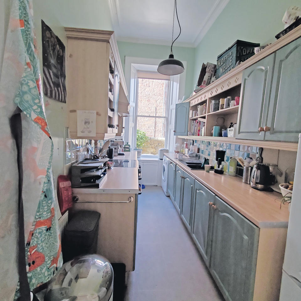 Shot of a narrow kitchen with a light grey floor and light green