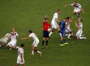 Germany's players celebrate as referee Nicola Rizzoli (C) of Italy signals the end of the extra time in their 2014 World Cup final against Argentina at the Maracana stadium in Rio de Janeiro July 13, 2014. REUTERS/David Gray