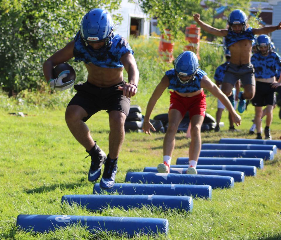 Somersworth High School running back Tayshawn Shepard jumps through a drill during the first practice of the season Friday, Aug. 12, 2022.