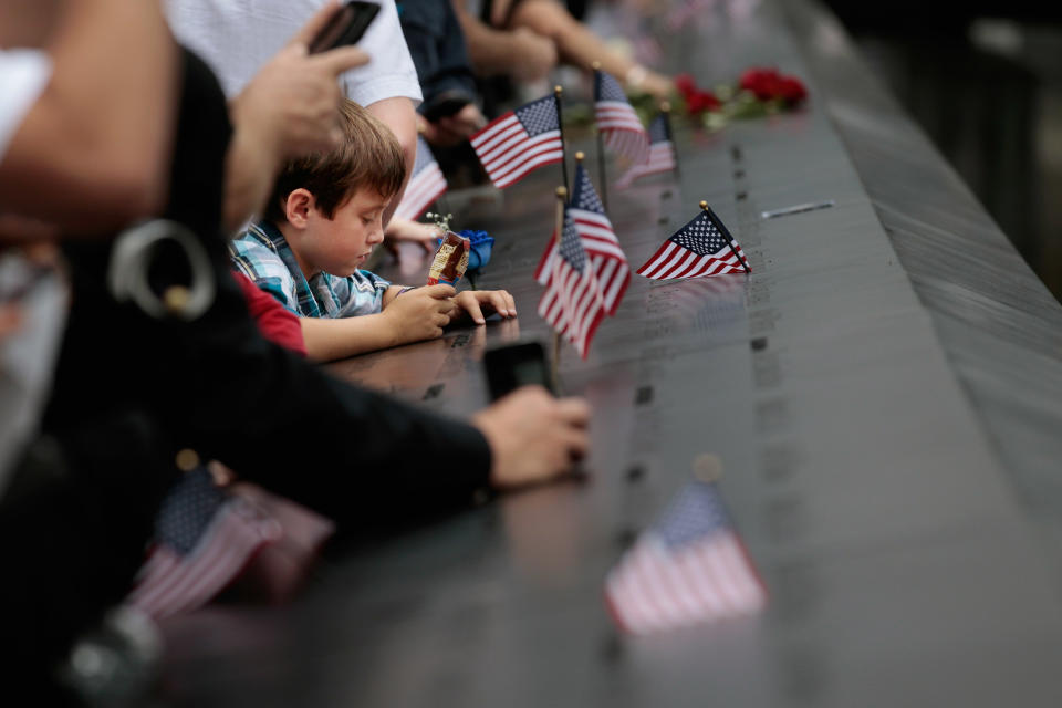 NEW YORK, NY - SEPTEMBER 11: Family members of the victims of the September 11 terror attacks stand at the perimeter of the 9/11 Memorial South Pool during the tenth anniversary ceremonies of the September 11, 2001 terrorist attacks at the World Trade Center site, September 11, 2011 in New York City. New York City and the nation are commemorating the tenth anniversary of the terrorist attacks which resulted in the deaths of nearly 3,000 people after two hijacked planes crashed into the World Trade Center, one into the Pentagon in Arlington, Virginia and one crash landed in Shanksville, Pennsylvania. (Photo by Chip Somodevilla/Getty Images)