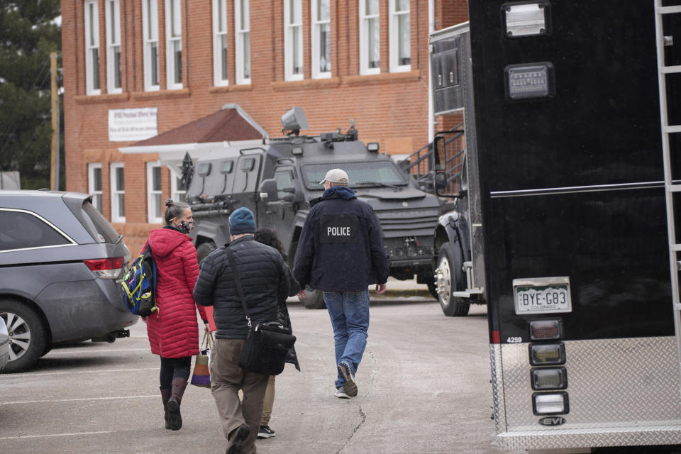 Police vehicles sit in front of University Hill Elementary School across from the campus of the University of Colorado after a man accused of making mass shooting threats against the college as well as the University of California, Los Angeles, was arrested Tuesday, Feb. 1, 2022, in Boulder, Colo. The police operation caused the evacuation of the elementary school and shelter-in-place orders for nearby residents on Boulder's University Hill. (AP Photo/David Zalubowski)