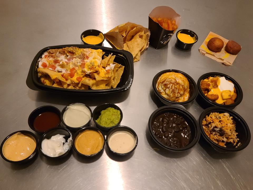 all of the side dishes, desserts, and sauces from taco bell sitting on a silver counter