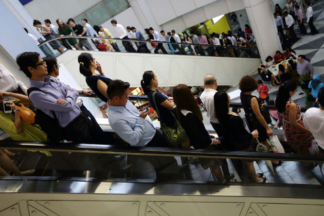 Commuters commute at lunch hour at Raffles Place on February 14, 2013 in Singapore. (Photo by Suhaimi Abdullah/Getty Images)