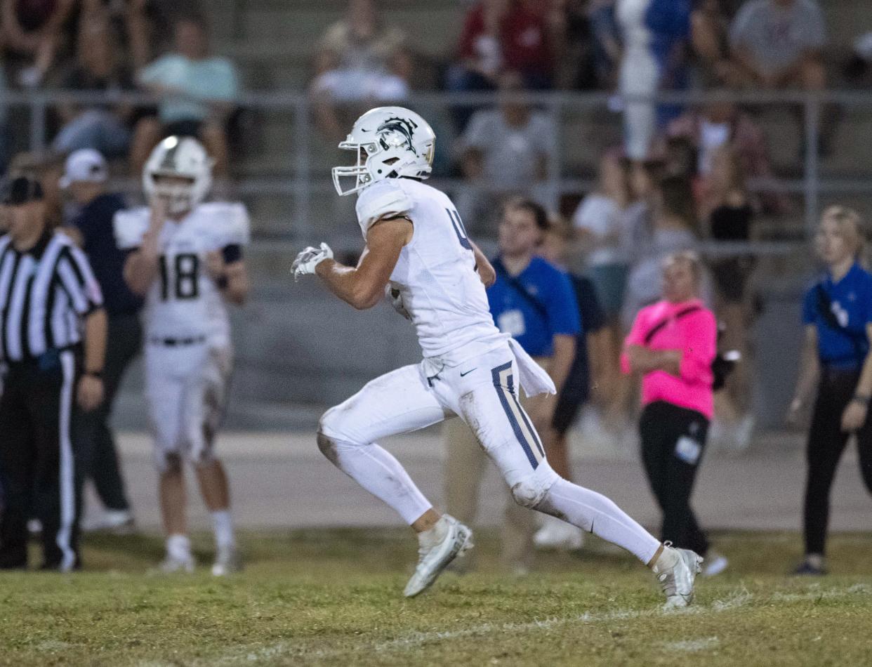 Jake Hooten (4) returns a kickoff for a 20-14 Dolphins lead during the Gulf Breeze vs Navarre football game at Navarre High School on Friday, Oct. 27, 2023.