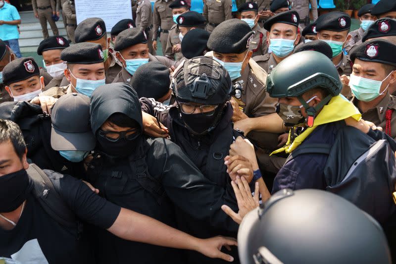 Volunteer guards of the anti-government protest movement scuffle with police officers at the Khlong Luang police station in Pathum Thani province,