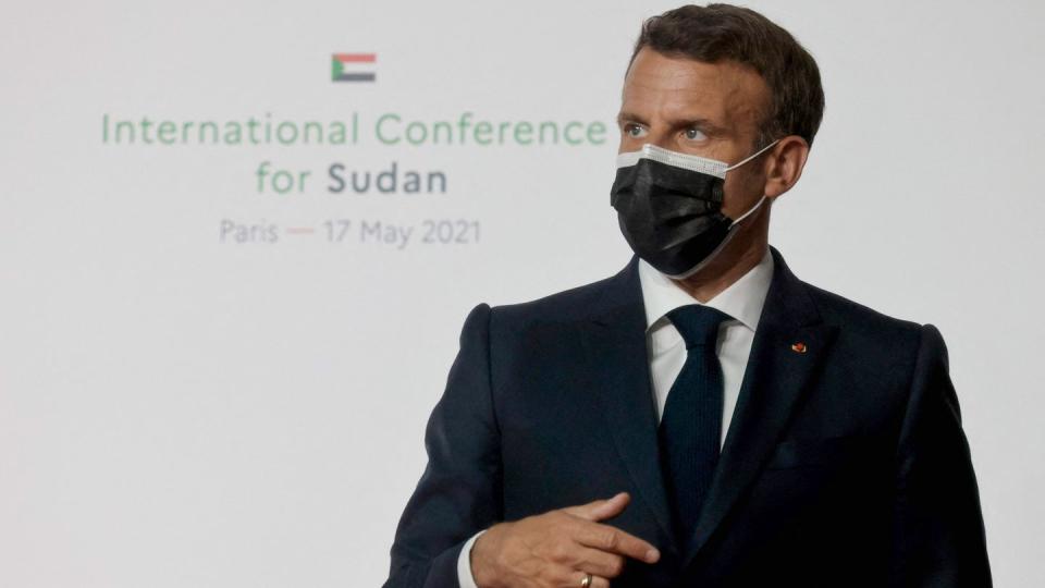 Emmanuel Macron, Präsident von Frankreich mit schwazrem Mundschutz vor weißer Wand, auf weißer Wand steht: International Conference for Sudan, Paris - 17 May 2021