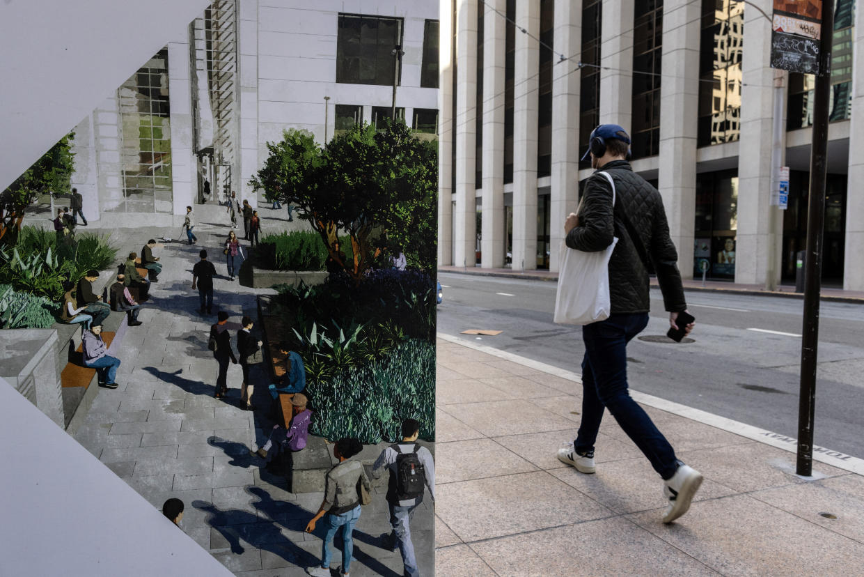 A person walks along an empty street in San Francisco, with at left, a photo of better times in a public space.