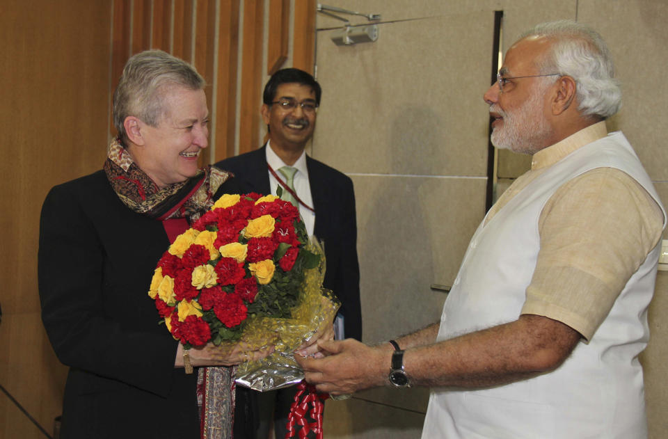 In this photo released by India's Gujarat state government, U.S. Ambassador to India, Nancy Powell, left, receives flowers presented to her by India’s opposition Bharatiya Janata Party’s prime ministerial candidate Narendra Modi, right, as she visits him at his residence in Gandhinagar, India, Thursday, Feb. 13, 2014. Powell on Thursday met with the Gujarat chief minister for the first time since he was refused a U.S. visa over alleged complicity in deadly anti-Muslim riots in 2002. (AP Photo/Gujarat state government)