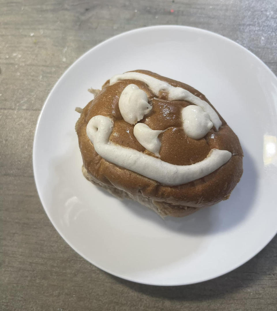 Hot cross bun with a smiley face design instead of a cross