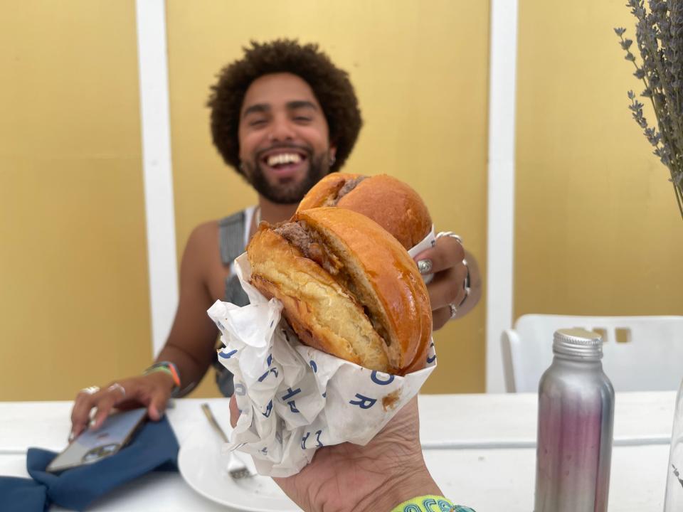 Malik cheersing a burger with a friend