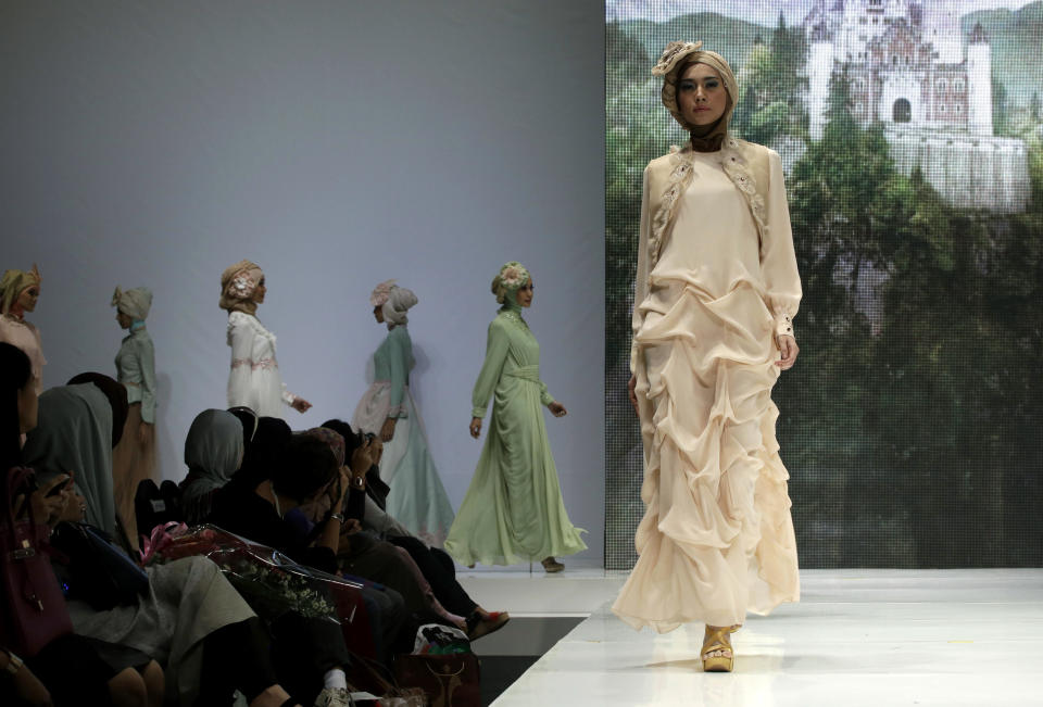 In this Thursday, May 30, 2013 photo, models showcase creations by Indonesian designer Poppy Theodorin during Ithe Islamic Fashion Fair in Jakarta, Indonesia. The event is part of the Indonesian government's effort to turn the most populous Muslim country into the world's Islamic fashion capital by 2020. (AP Photo/Dita Alangkara)