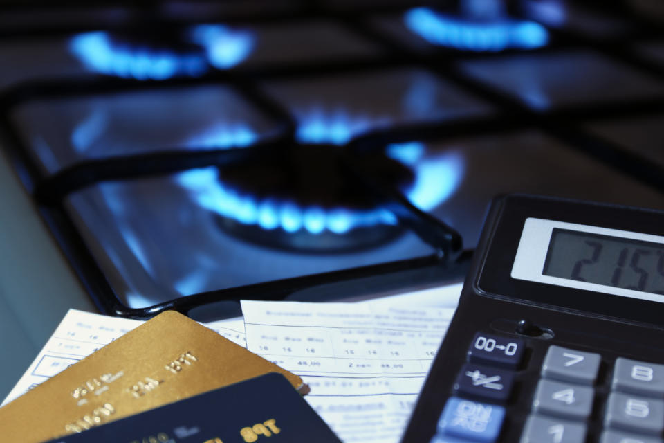 bank cards and a calculator on the background of a burning  gas stove