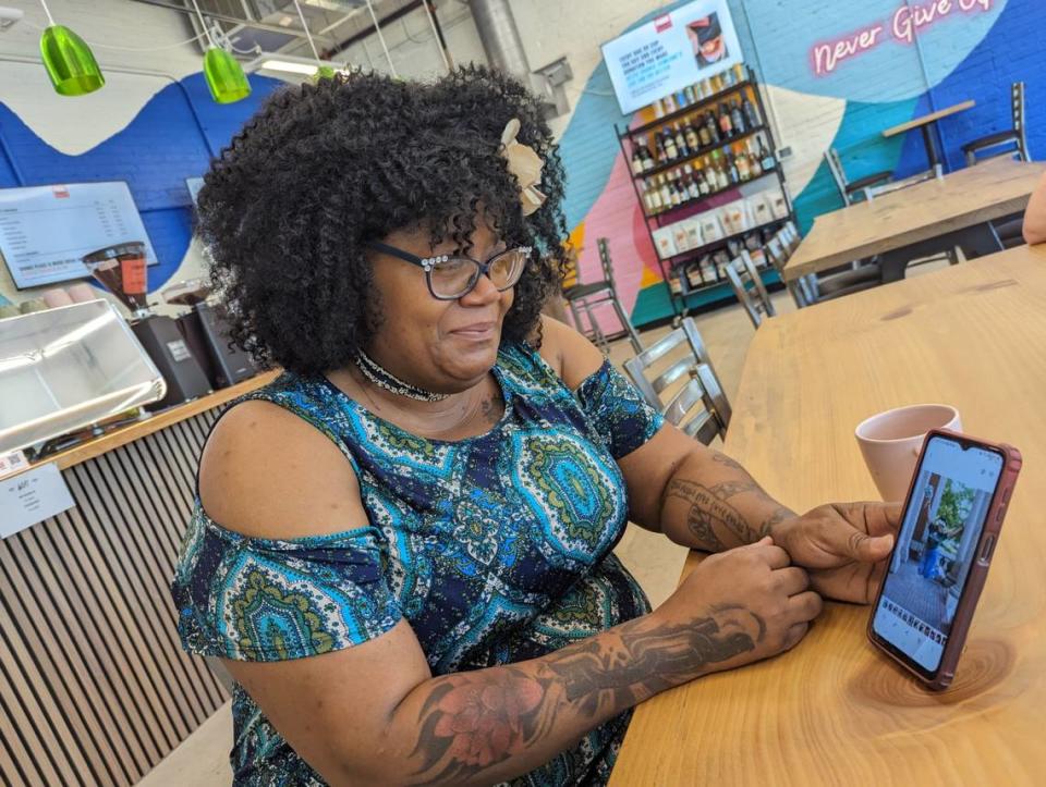 Monique Mims, the first trained barista at Change Please Coffee in Charlotte, holds her phone showing a picture of her daughter, who is a pre-med student at UNC Charlotte. “This is my greatest success,” she said.