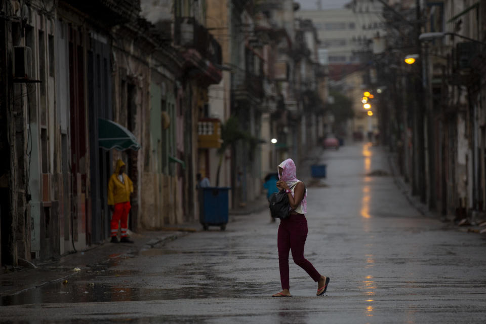 Un peatón cruza una calle vacía durante el paso del huracán Ian en La Habana, Cuba, la madrugada del jueves 27 de septiembre de 2022. (AP Foto/Ismael Francisco)