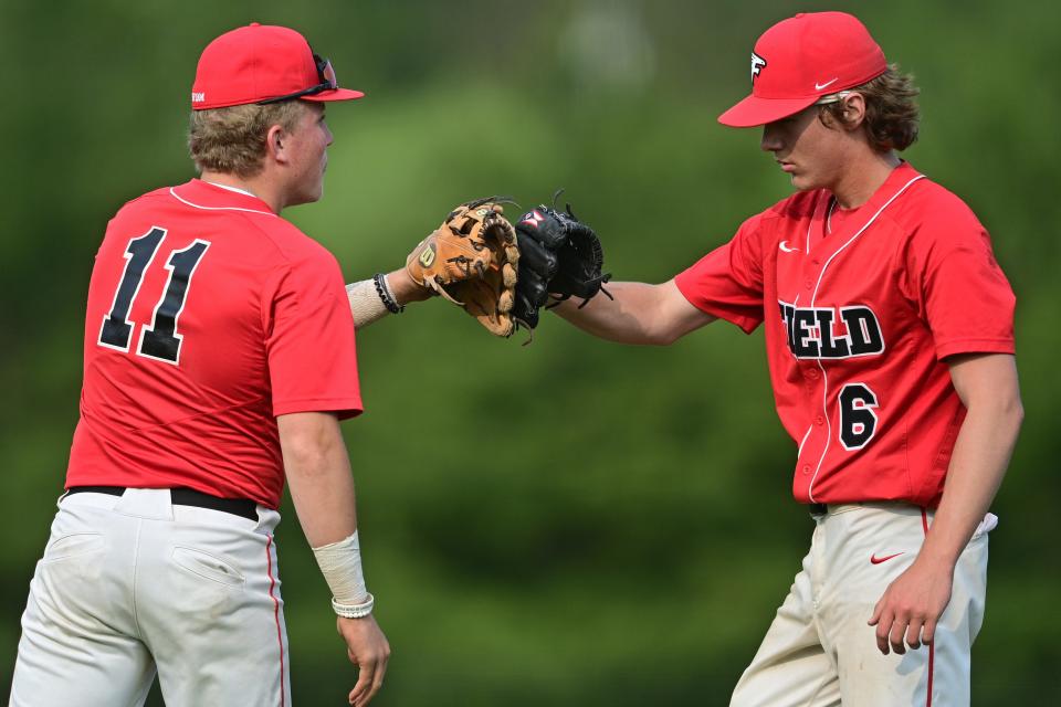 Field starting pitcher Caleb Gartner, right, gets a fist bump from Braxton Baumberger after an out during the seventh inning of their OHSAA tournament game Monday night at Cane Park in Struthers, Ohio.